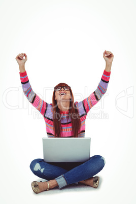 Smiling hipster woman using laptop while putting hands up