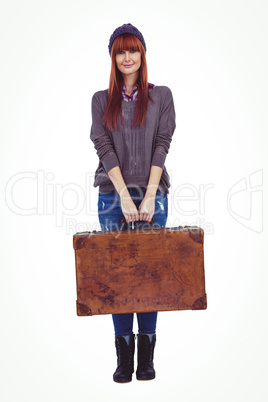 Smiling hipster woman holding suitcase