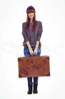 Smiling hipster woman holding suitcase