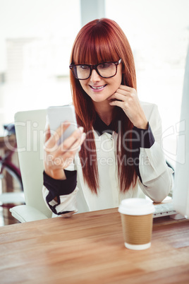 Smiling hipster businesswoman taking selfie