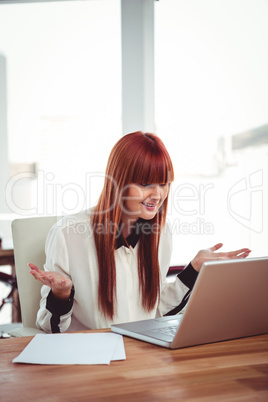 Confused hipster businesswoman using her laptop