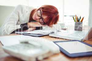 Hipster businesswoman falling in sleep at her desk