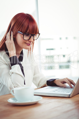 Hipster businesswoman using her laptop
