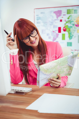 Smiling hipster businesswoman looking a map