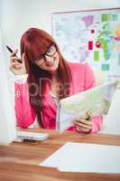 Smiling hipster businesswoman looking a map