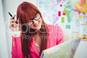 Smiling hipster businesswoman looking a map