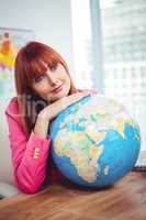 Hipster businesswoman lean on a globe