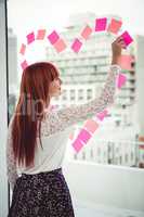 Rear view of a hipster woman doing a heart in post-it