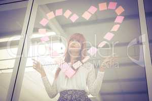 Smiling hipster woman doing a heart in post-it