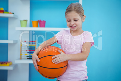Cute girl holding basket ball