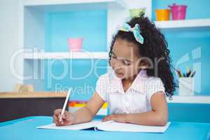 Cute girl writing on notebook