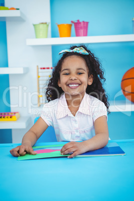 Cute girl with a book smiling at camera