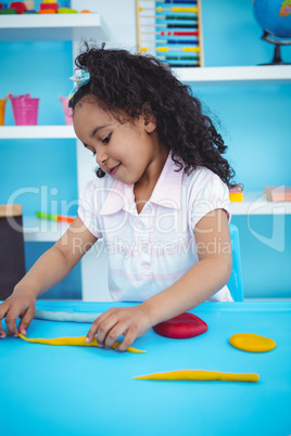Cute girl playing with modeling clay