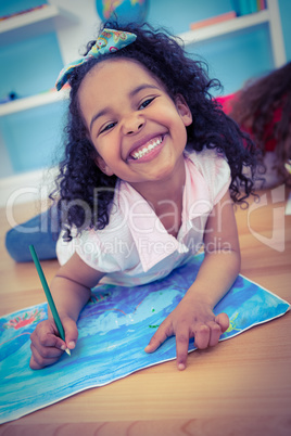 Cute girl drawing and smiling at the camera