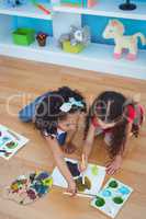 Cute girls painting laying on the floor