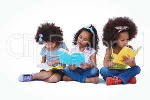 Cute girls sitting on the floor reading books