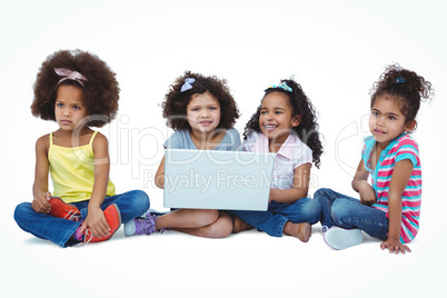 Cute girls sitting on the floor using laptop