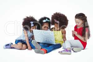 Cute girls sitting on the floor using laptop