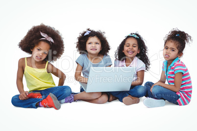 Cute girls sitting on the floor using laptop