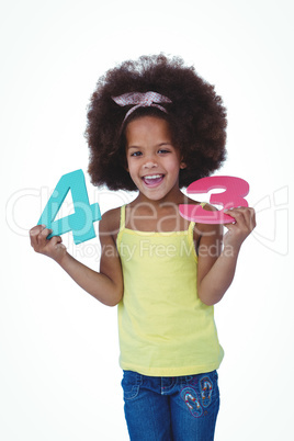 Cute girl standing holding sponge numbers