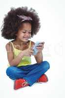 Cute girl sitting on floor using smartphone