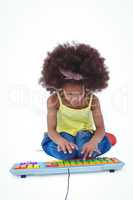 Cute girl sitting on the floor using a colored keyboard