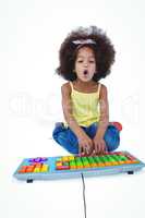 Cute girl sitting on the floor using colored keybord