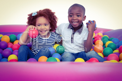 Cute children in ball pool holding balls