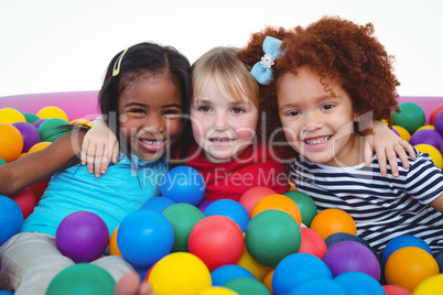 Cute smiling girls in sponge ball pool hugging