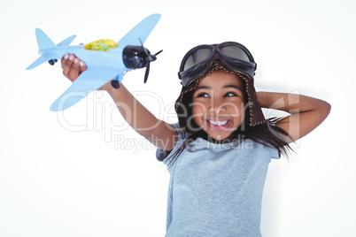 Smiling girl laying on the floor playing with toy airplane