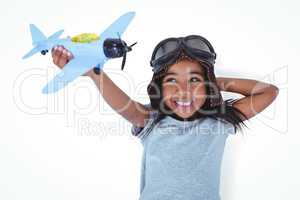 Smiling girl laying on the floor playing with toy airplane
