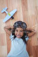 Smiling girl laying on the floor wearing aviator glasses and hat