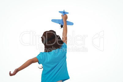 Standing girl playing with toy airplane