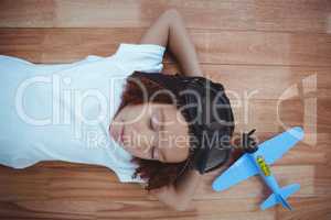 Smiling girl sleeping on the floor wearing aviator glasses and h