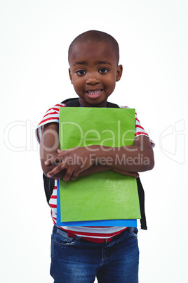 Standing boy with backpack holding notebooks