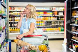 Beautiful woman with cart choosing product