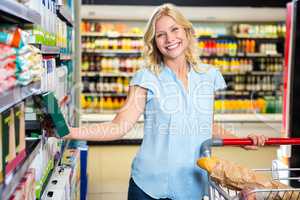 Smiling woman taking food from shelf