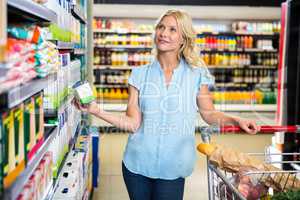 Thoughtful woman holding product