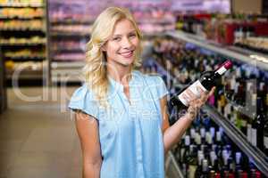 Smiling woman holding wine bottle