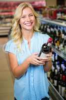 Smiling woman holding wine bottle