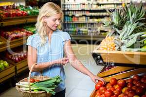 Blonde woman taking tomatoes