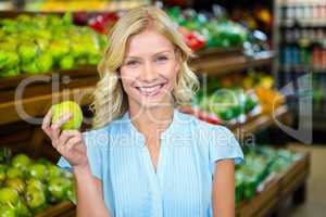 Smiling woman holding green apple