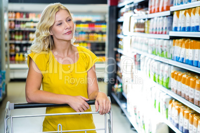Blond woman pushing cart choosing products