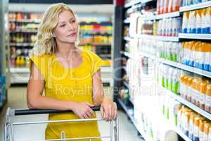 Blond woman pushing cart choosing products