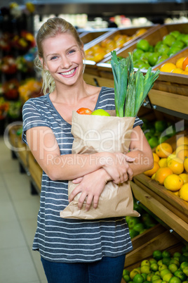Smiling woman holding grocery bag