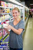 Smiling woman holding milk bottle