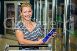 Smiling woman with cart holding product