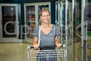 Portrait of smiling woman pushing cart