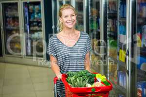 Portrait of smiling woman pushing shopping basket