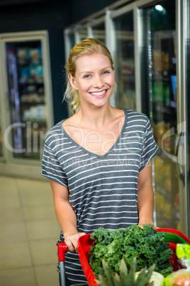 Portrait of smiling woman pushing shopping basket